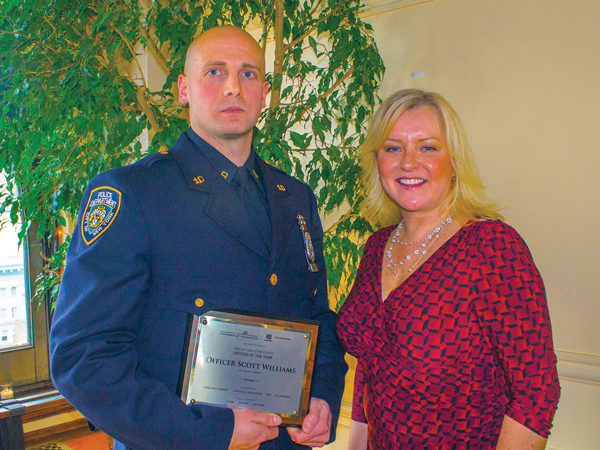 Photo by Zach Williams NYC Community Media publisher Jennifer Goodstein, with NYPD Officer Scott Williams of the 10th Precinct (holding his Officer of the Year award). Williams played a key role in the arrest of two foreign nationals who were using the identities of 53 different individuals to withdraw money from local ATMs.