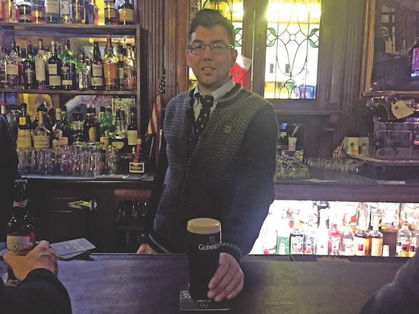 Fourth-generation Peter McManus Café owner Justin McManus serves up a well-poured Guinness. File photo by Dennis Lynch.
